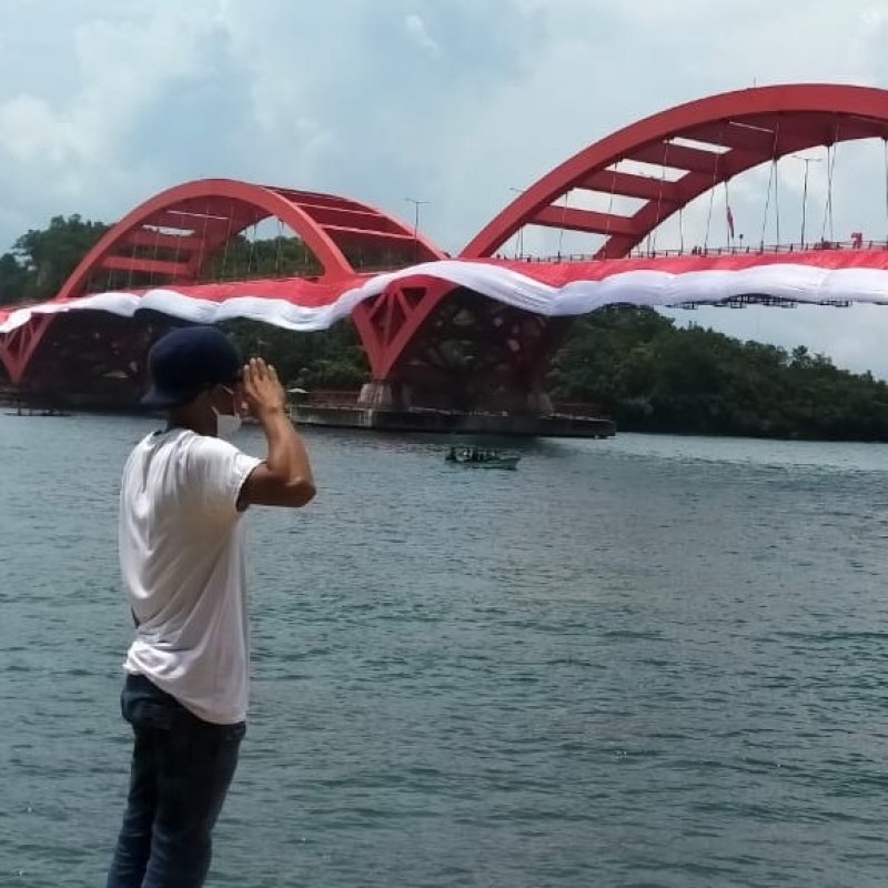 Bersinergi dengan Warga Papua, Banser Bentangkan Bendera di Jembatan Merah Youtefa